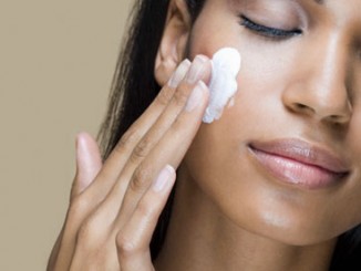 A woman rubbing moisturizer into her skin